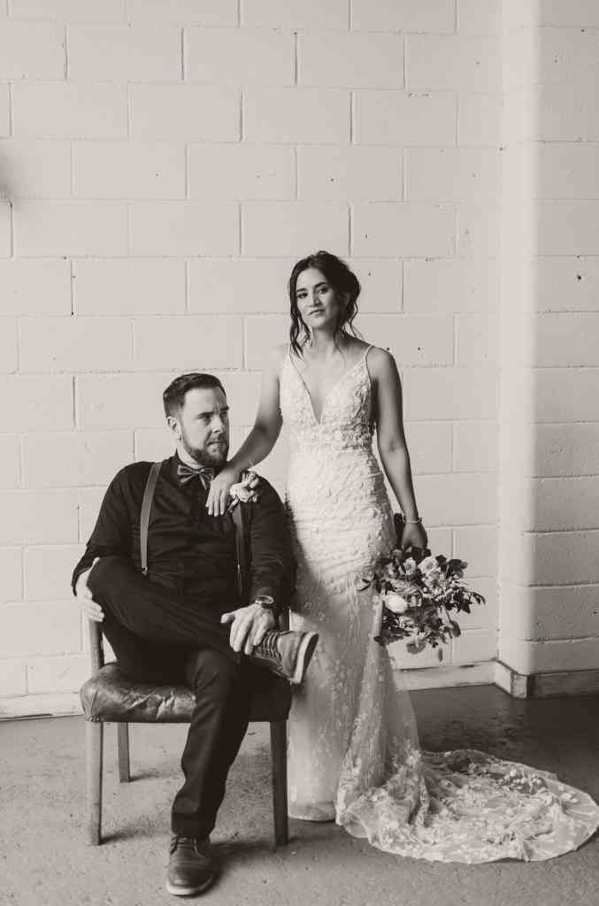 A newlywed couple poses for a black and white editorial style photo at the Rustic Reel in downtown Kelowna, BC