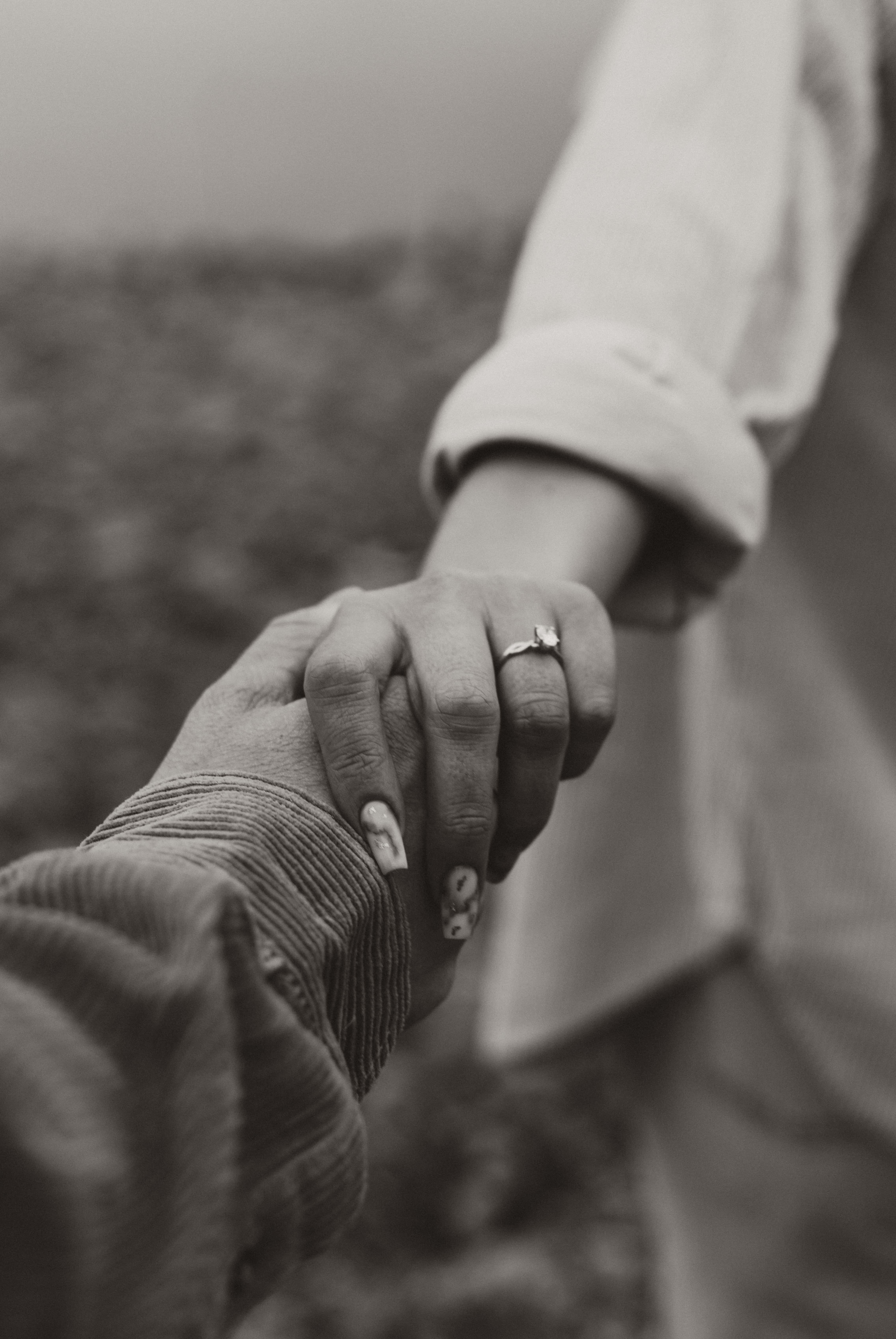 An engaged couple walk hand in hand along the beach in Lake Country, Okanagan, BC