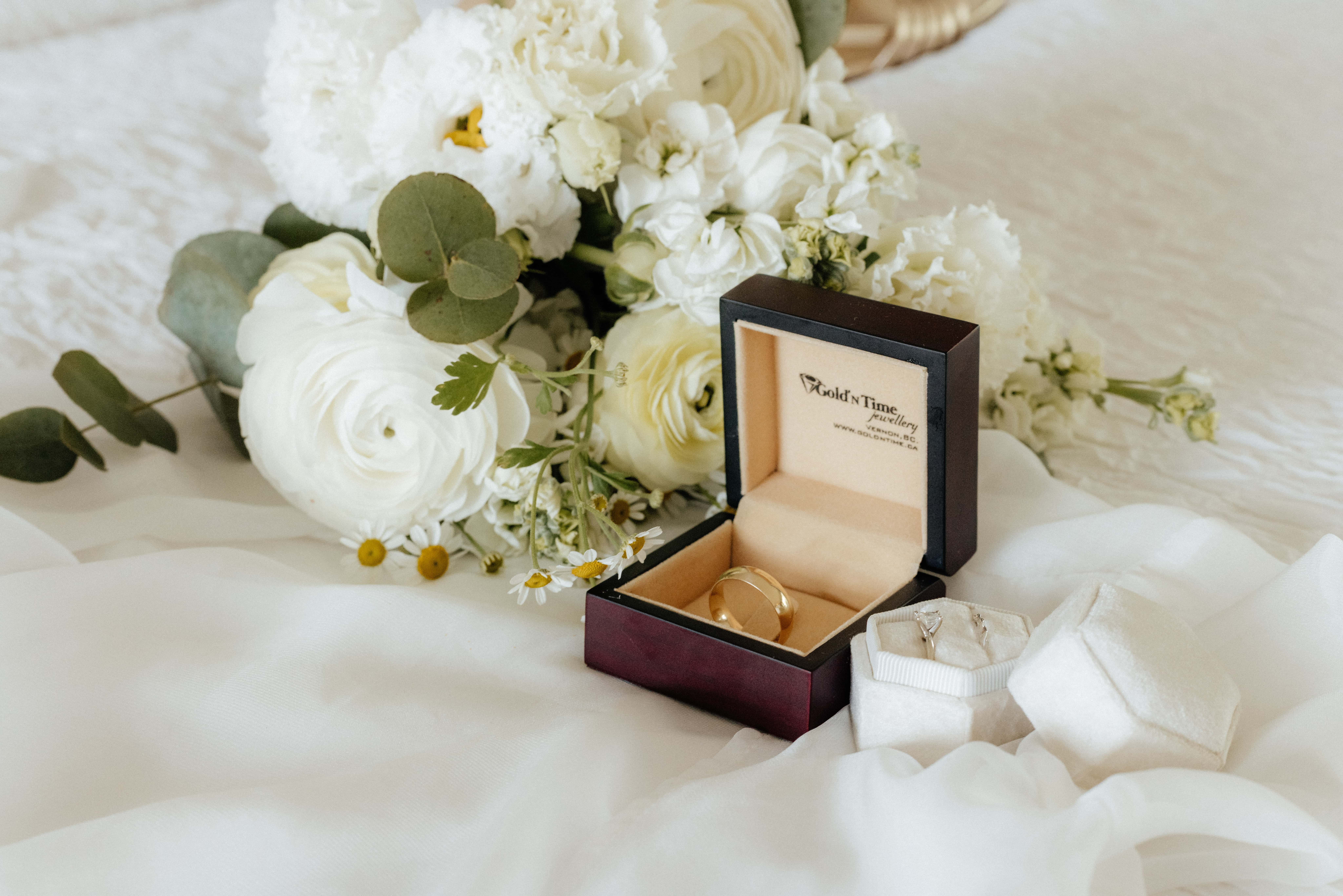 A beautiful detail shot of a bride and groom's wedding rings with the bridal bouquet and veil