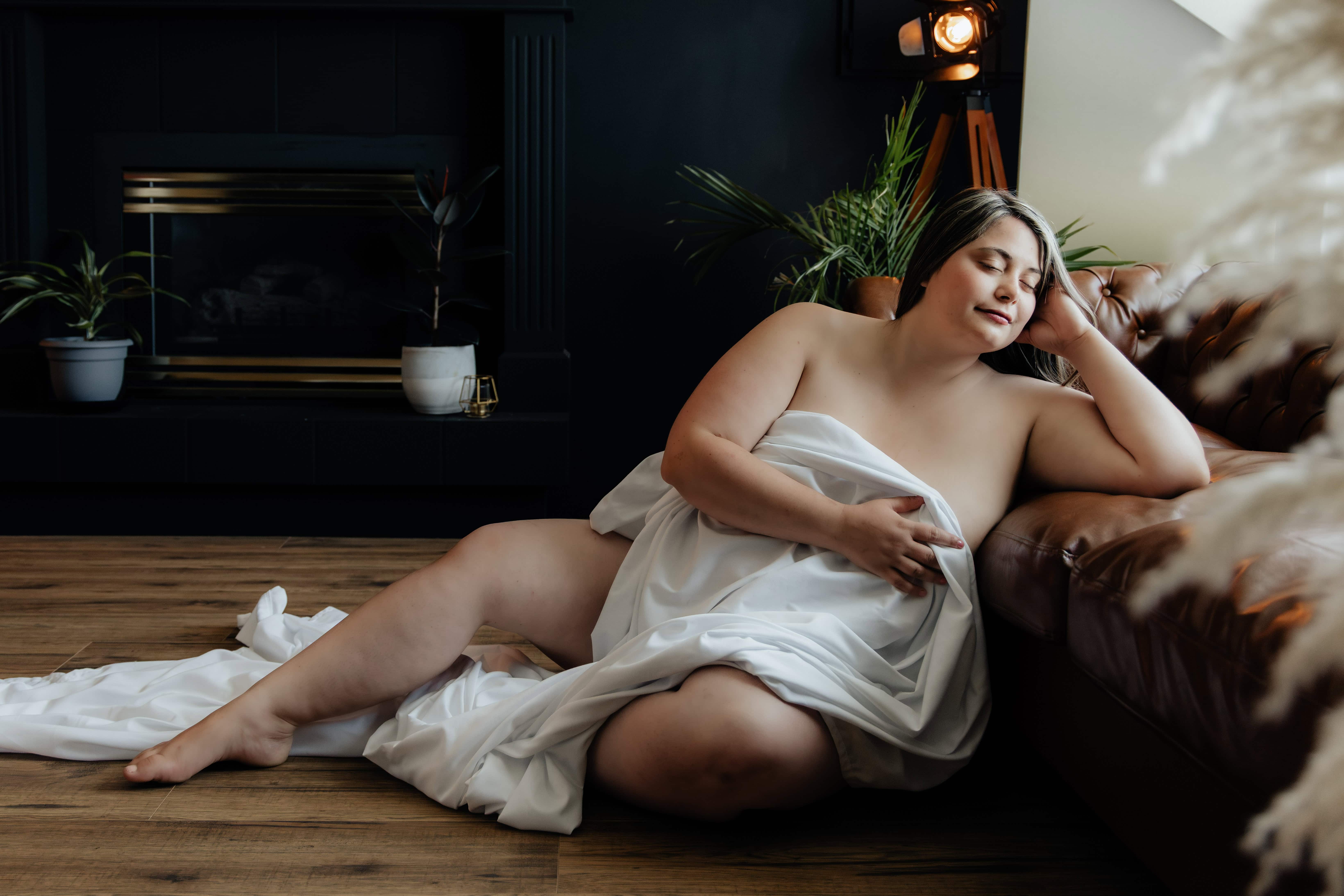 A gorgeous plus-size woman poses for an intimate boudoir photo in a photo studio in the Okanagan