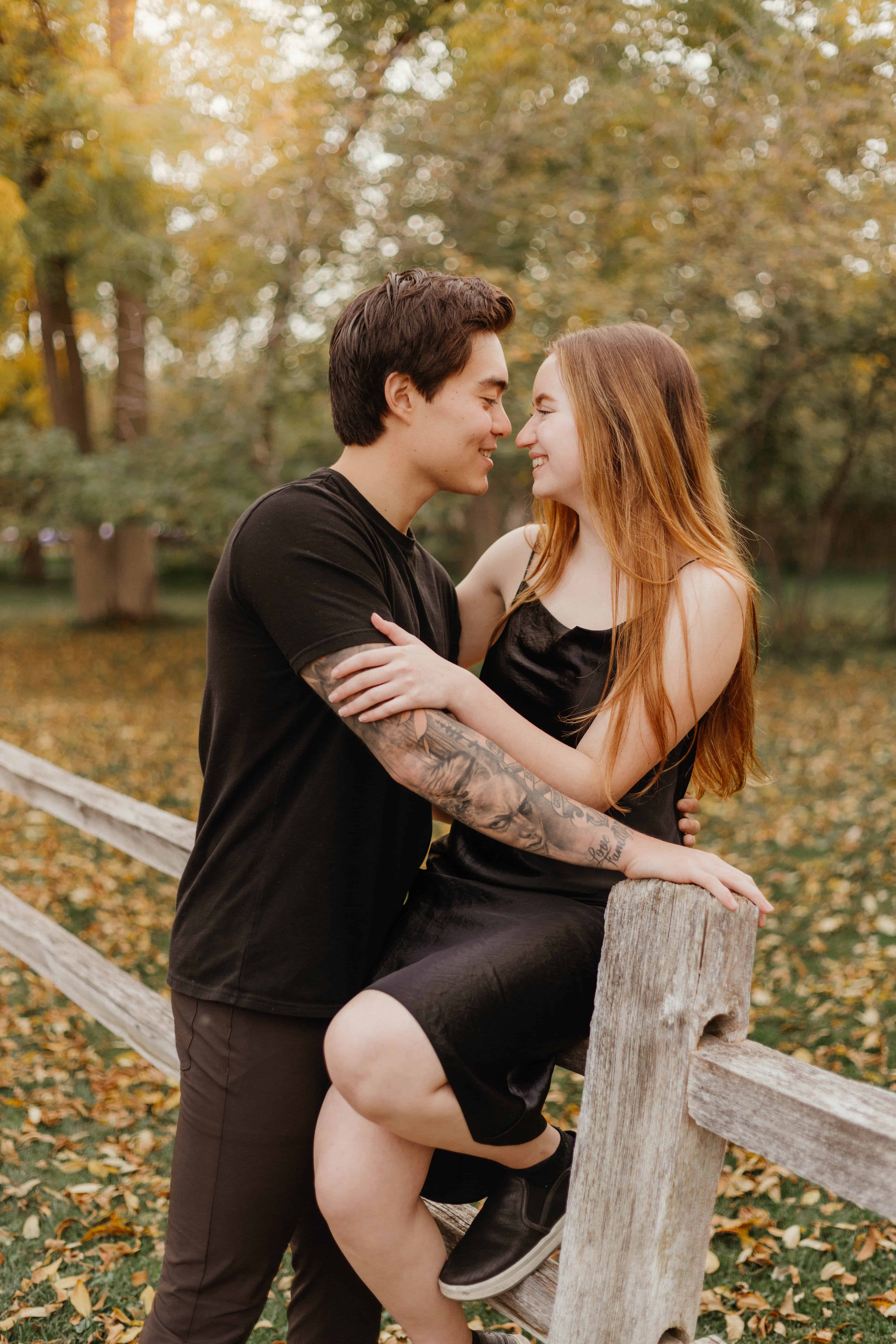 A sweet couple leans in for a kiss during their fall couples photoshoot at Gellatly Nut Farm in West Kelowna, Okanagan