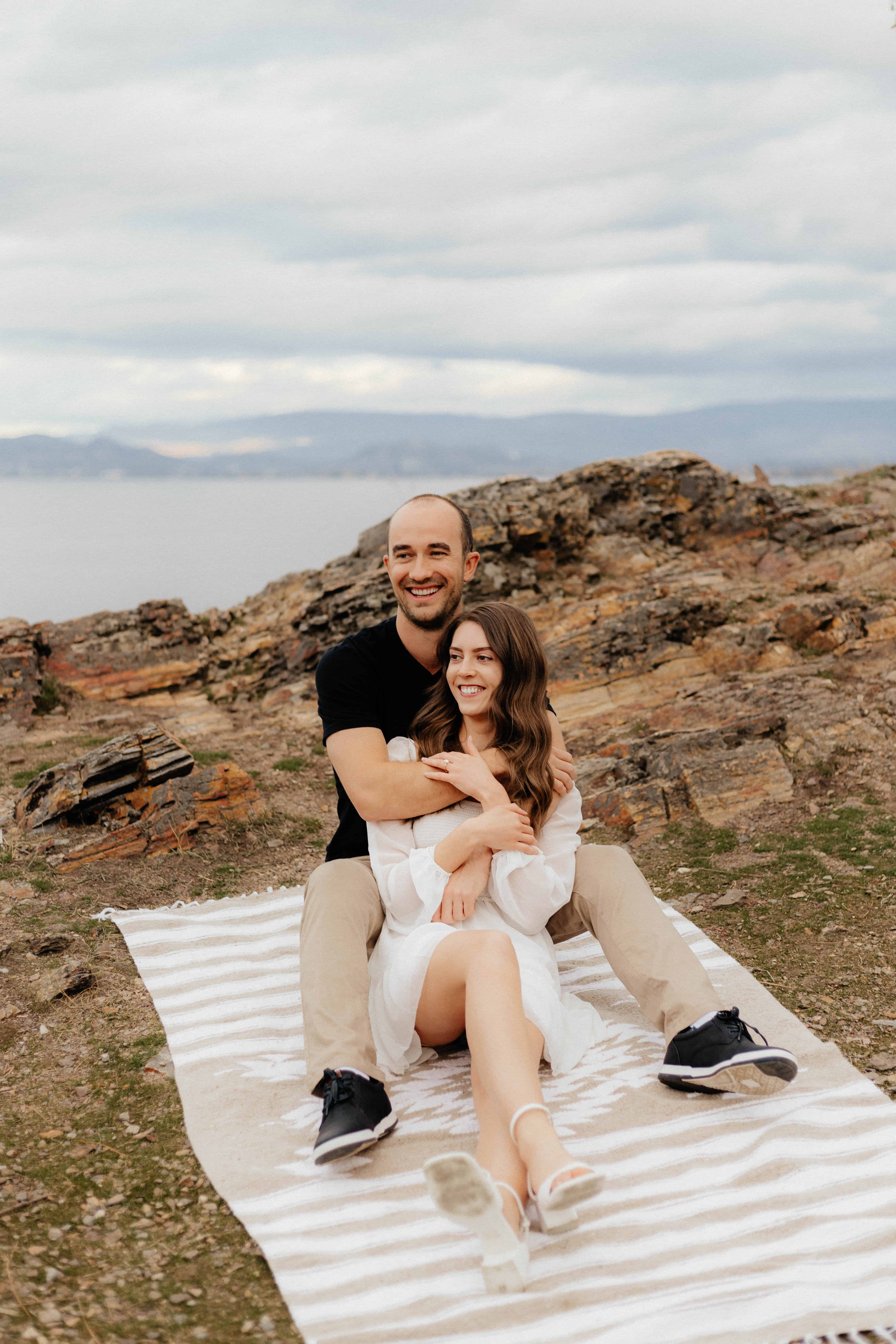 A beautiful couple smiles for a portrait during their engagement session in Kelowna, BC