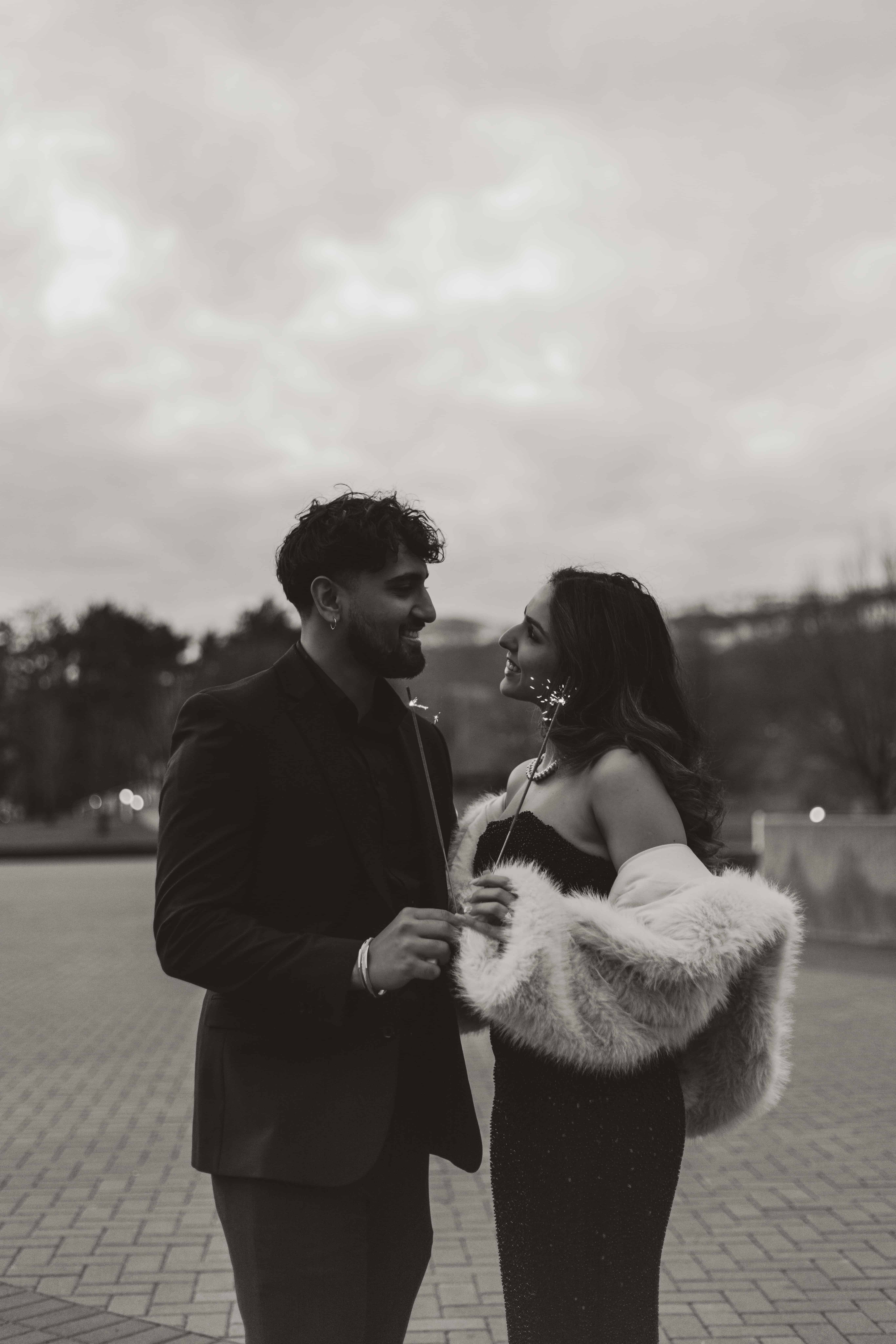 A black and white photograph of a couple holding sparklers while celebrating a birthday in Kelowna, BC