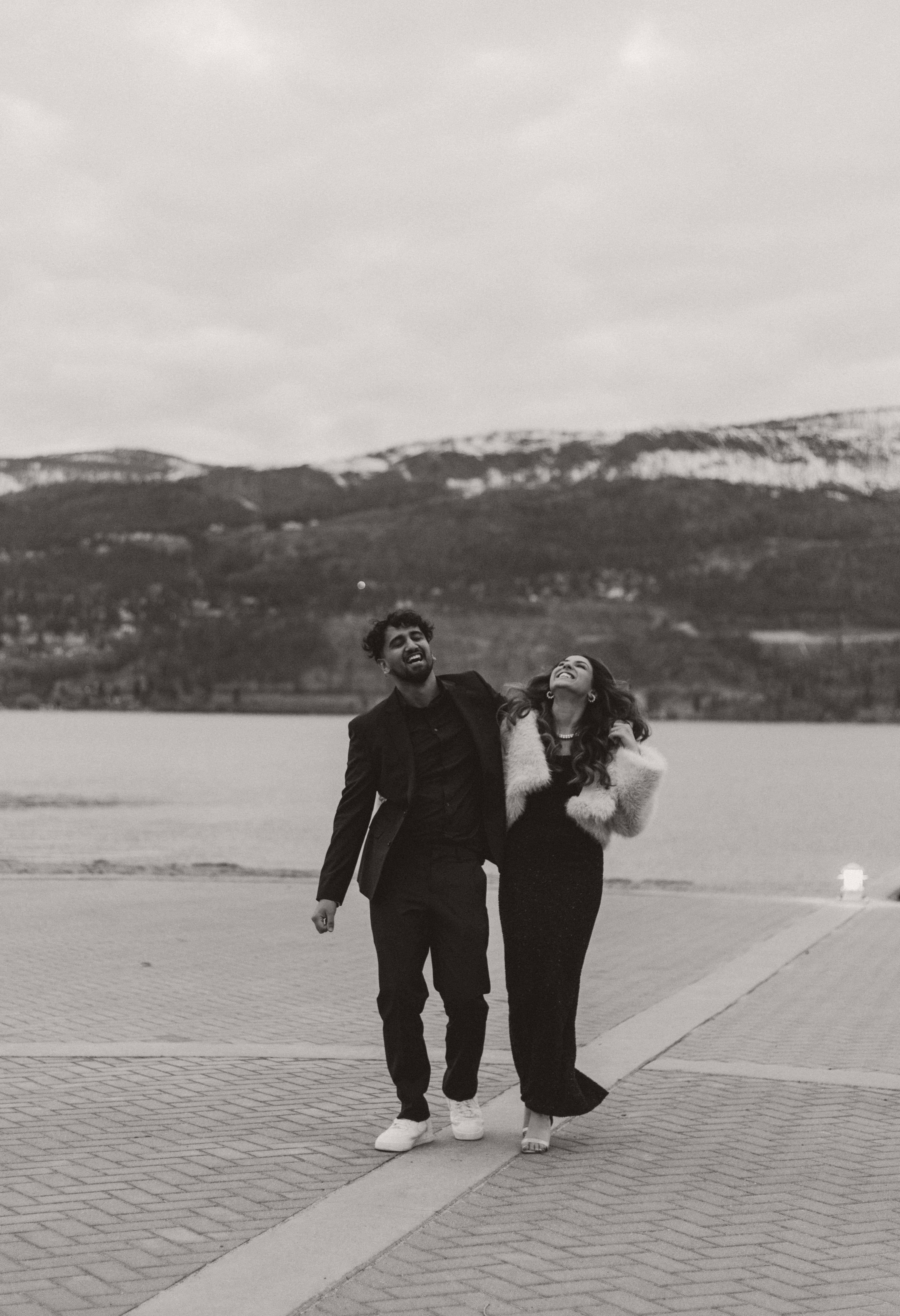A glammed up couple giggles as they walk in front of Lake Okanagan in downtown Kelowna, BC