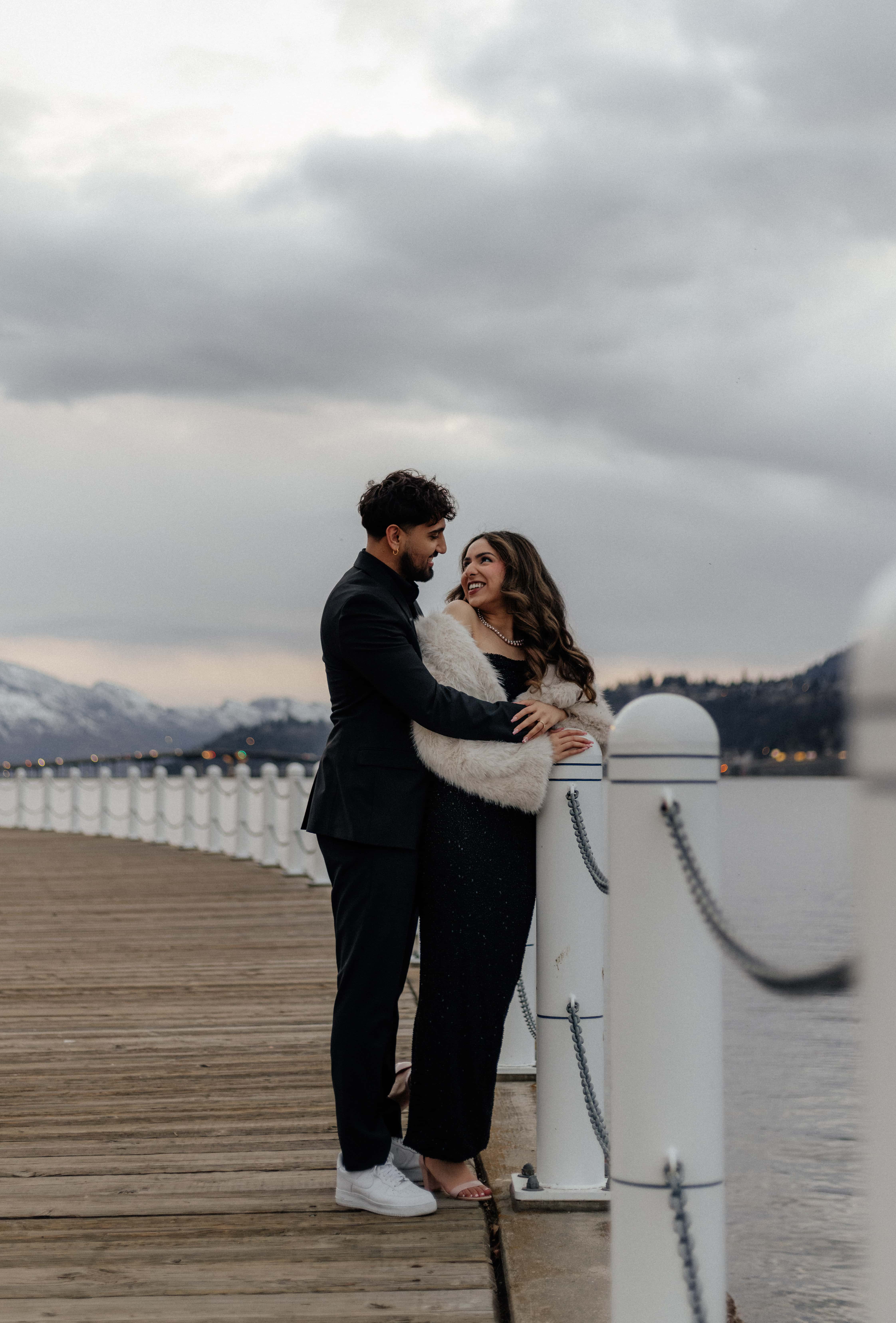 A beautiful couple poses for a candid snapshot on the boardwalk in front of Lake Okanagan in downtown Kelowna