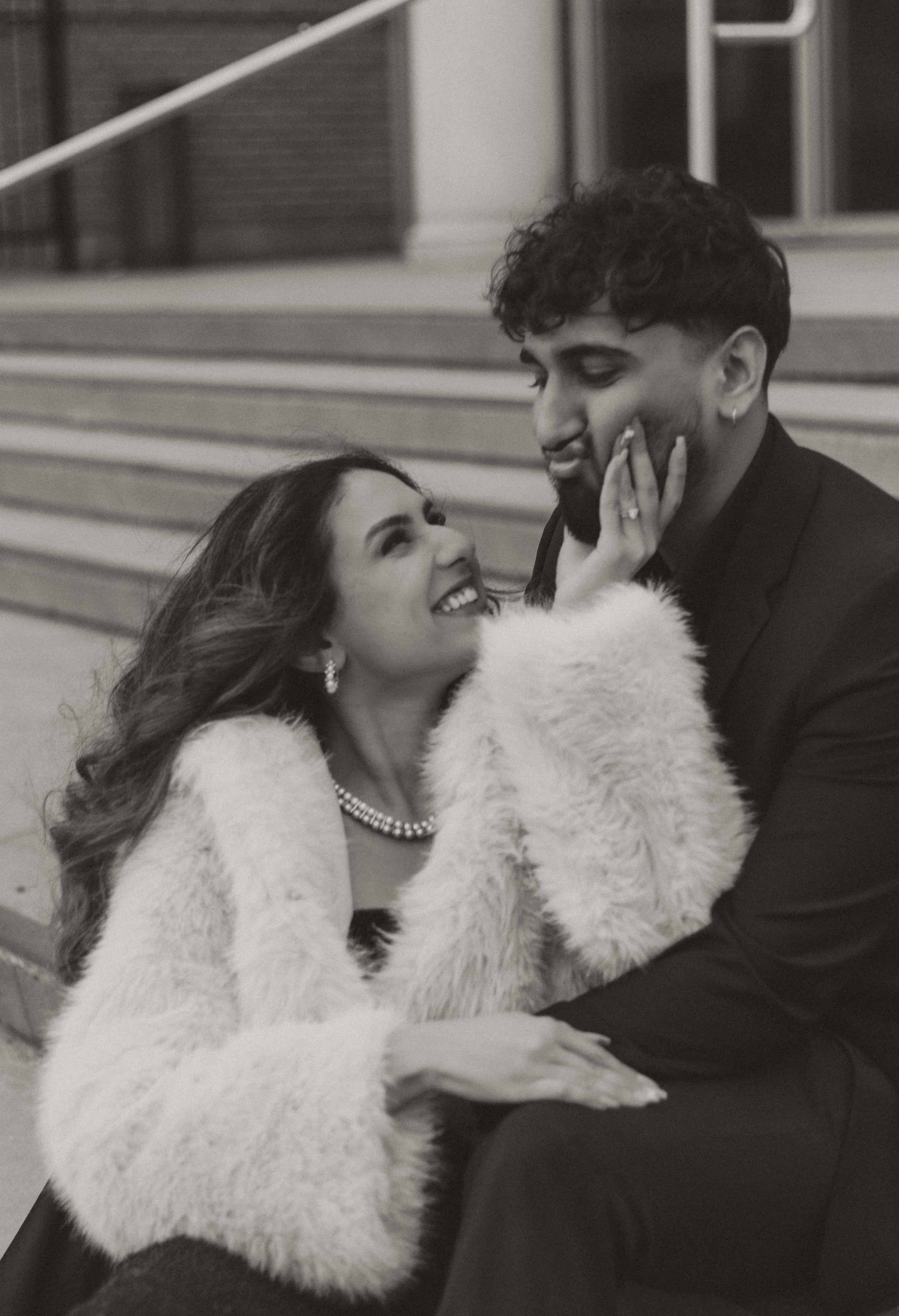 A cute black and white photo of a couple having fun on a staircase in downtown Kelowna, BC