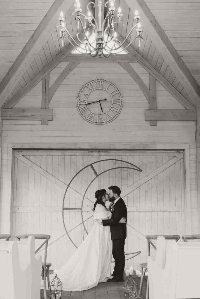 A bride and groom share their first kiss after eloping at Sanctuary Gardens in Kelowna