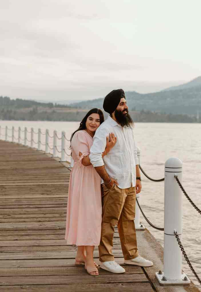 A couple poses for a lovely snapshot on the boardwalk in downtown Kelowna in front of Lake Okanagan
