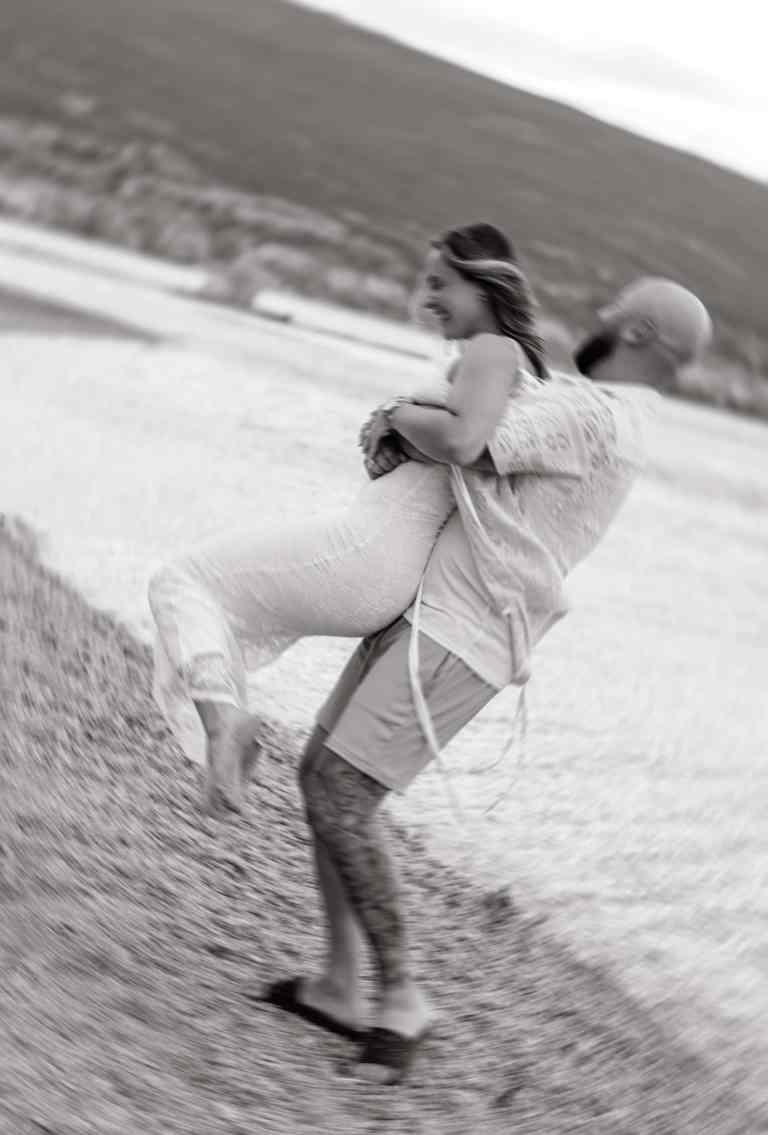 A couple being playful on the beach during their engagement session in Summerland, BC