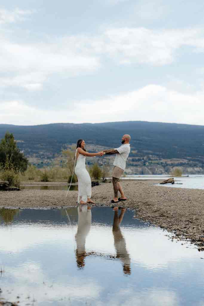 A couple dances on the beach during their fun engagement photoshoot in Summerland at Sun-Oka Beach in the Okanagan